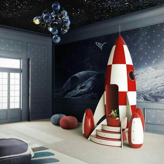 A children's room decorated with wallpaper and a rocket ship playhouse