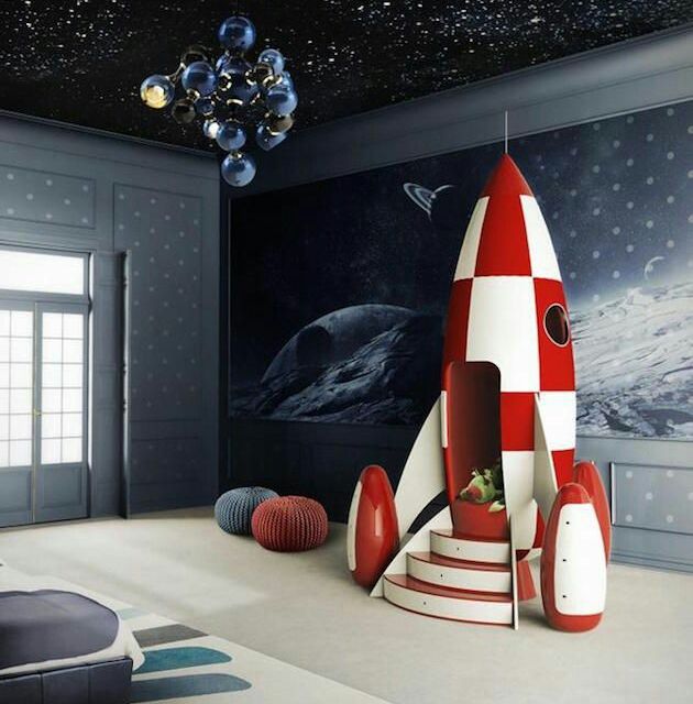 A children's room decorated with wallpaper and a rocket ship playhouse
