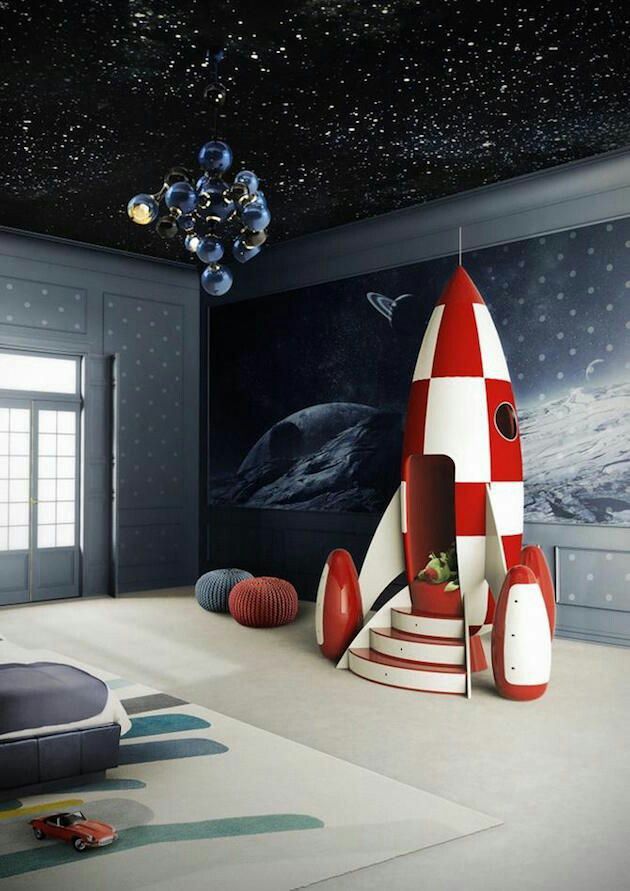 A children's room decorated with wallpaper and a rocket ship playhouse